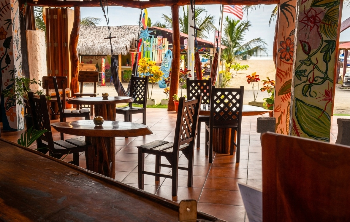Open-air café with wooden tables and chairs, warm sunlight, and tropical decor.