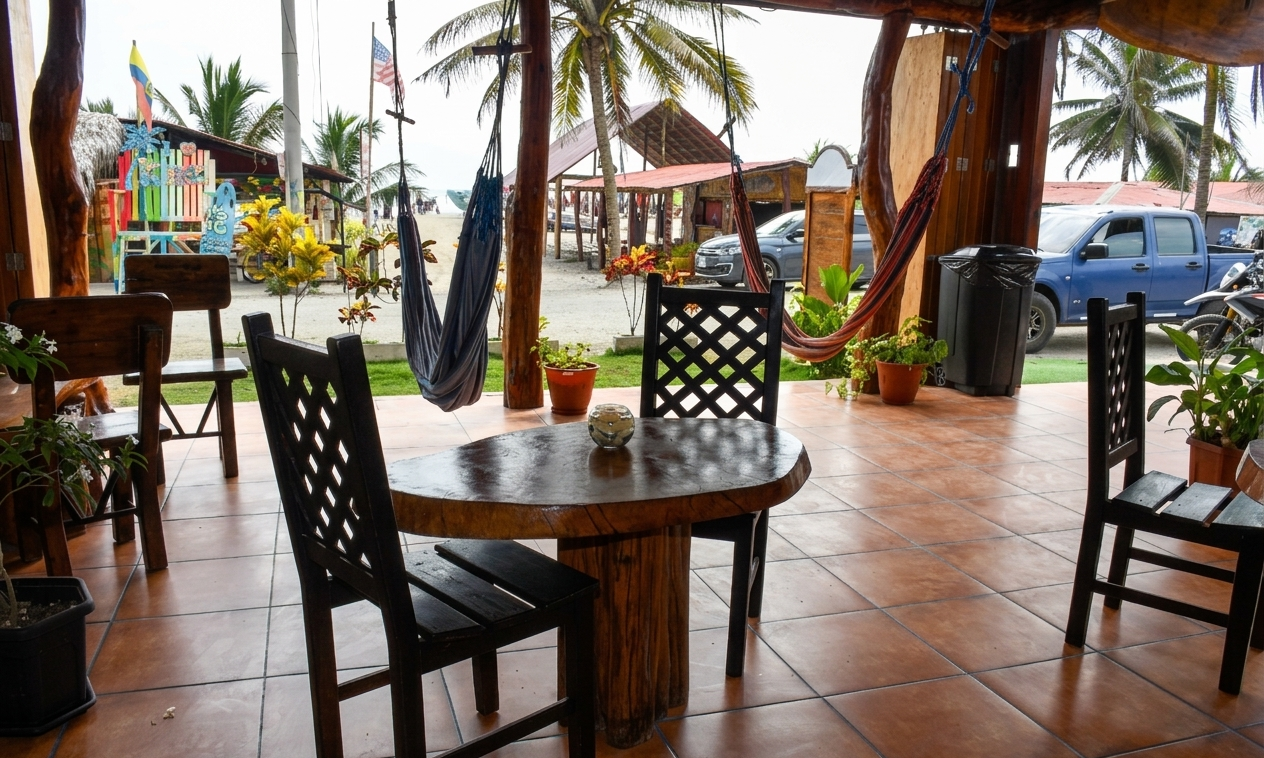 Open-air café with wooden tables and chairs on a tiled patio by the street