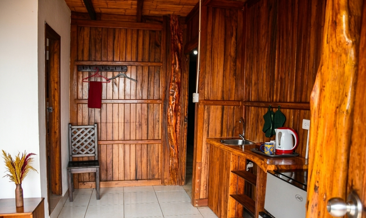 Wood-paneled kitchen interior with shelves, a small table, chair, and tiled floor