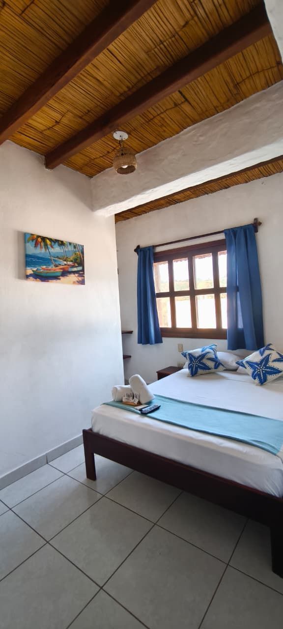 Wooden bunk bed with white and turquoise bedding in a peach-colored room