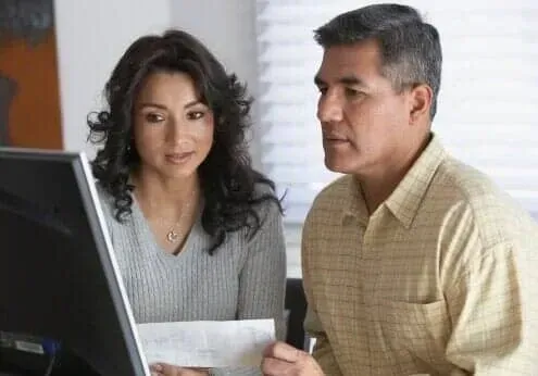 Two people reviewing a computer screen in an office setting