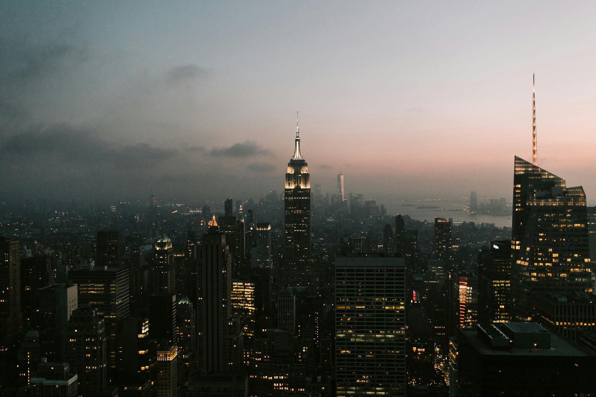 New York City skyline at dusk, with the Empire State Building illuminated.
