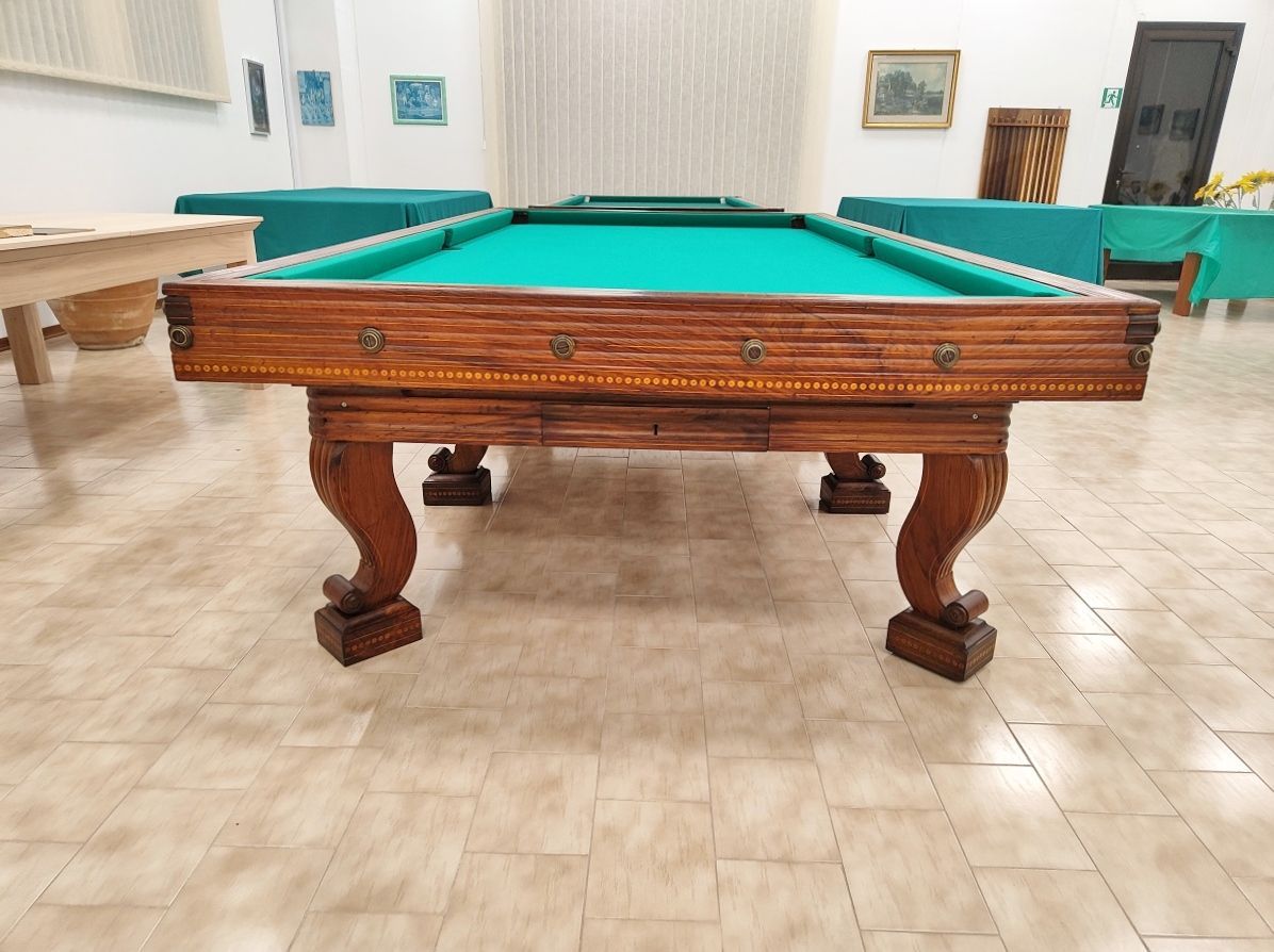 Biliardo del ‘700 autentico ed integro
in ogni sua parte, finemente restaurato secondo i dettami dell’epoca, lucidato a spirito e finitura a cera.
Il piano di gioco è in legno, anch’esso spianato con pialle manuali e restaurato.
Il biliardo è completamente realizzato in massello di noce e le parti esterne sono arricchite da numerosi intarsi e sottili filetti di acero.
Campo gioco 2,90x1,45 – pezzo unico
