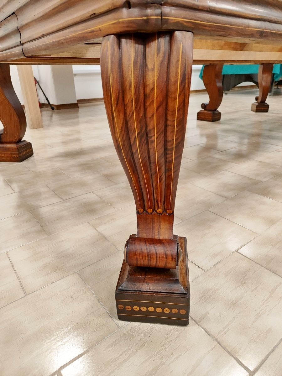 Biliardo del ‘700 autentico ed integro
in ogni sua parte, finemente restaurato secondo i dettami dell’epoca, lucidato a spirito e finitura a cera.
Il piano di gioco è in legno, anch’esso spianato con pialle manuali e restaurato.
Il biliardo è completamente realizzato in massello di noce e le parti esterne sono arricchite da numerosi intarsi e sottili filetti di acero.
Campo gioco 2,90x1,45 – pezzo unico