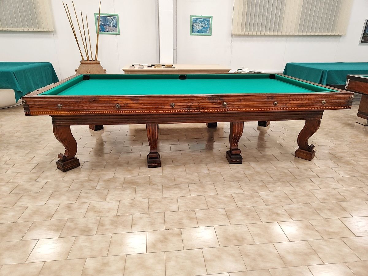 Biliardo del ‘700 autentico ed integro
in ogni sua parte, finemente restaurato secondo i dettami dell’epoca, lucidato a spirito e finitura a cera.
Il piano di gioco è in legno, anch’esso spianato con pialle manuali e restaurato.
Il biliardo è completamente realizzato in massello di noce e le parti esterne sono arricchite da numerosi intarsi e sottili filetti di acero.
Campo gioco 2,90x1,45 – pezzo unico