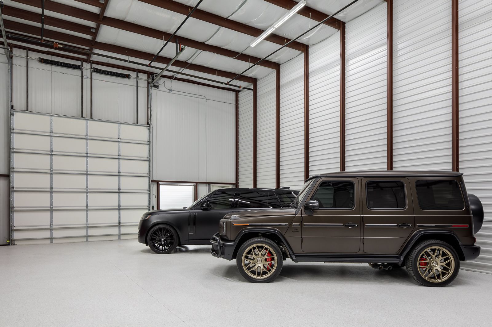Two SUVs parked inside a private garage suite at The Lux in Overland Park