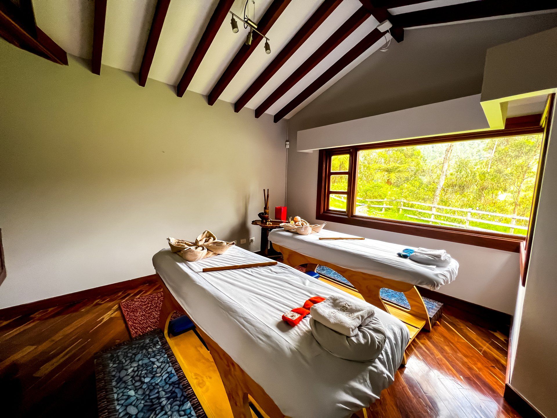 Sala de spa con dos camillas y vista exterior, experiencia de bienestar en hotel cerca a Manizales.