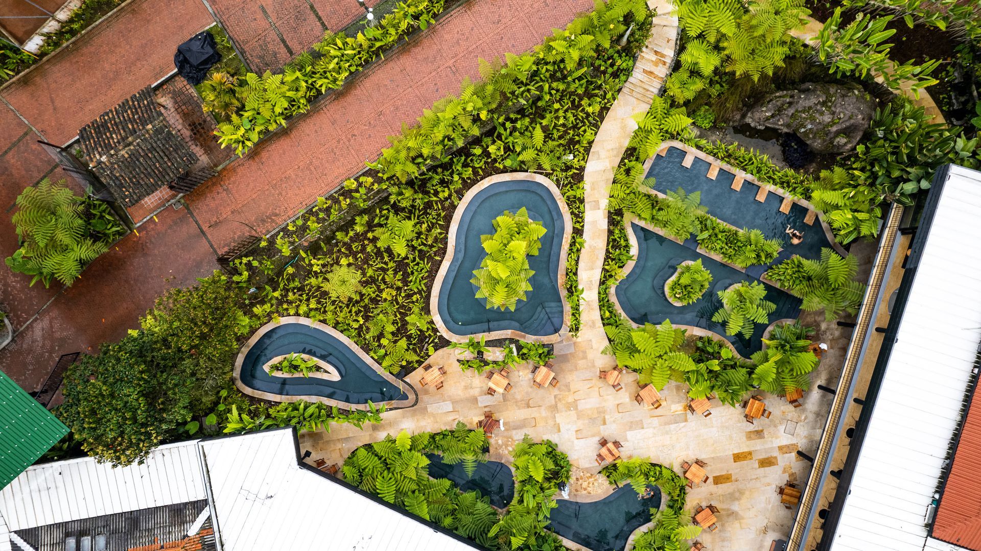 Vista aérea de charcos y piscinas de aguas termales rodeadas de jardines en Termales El Otoño, Manizales.