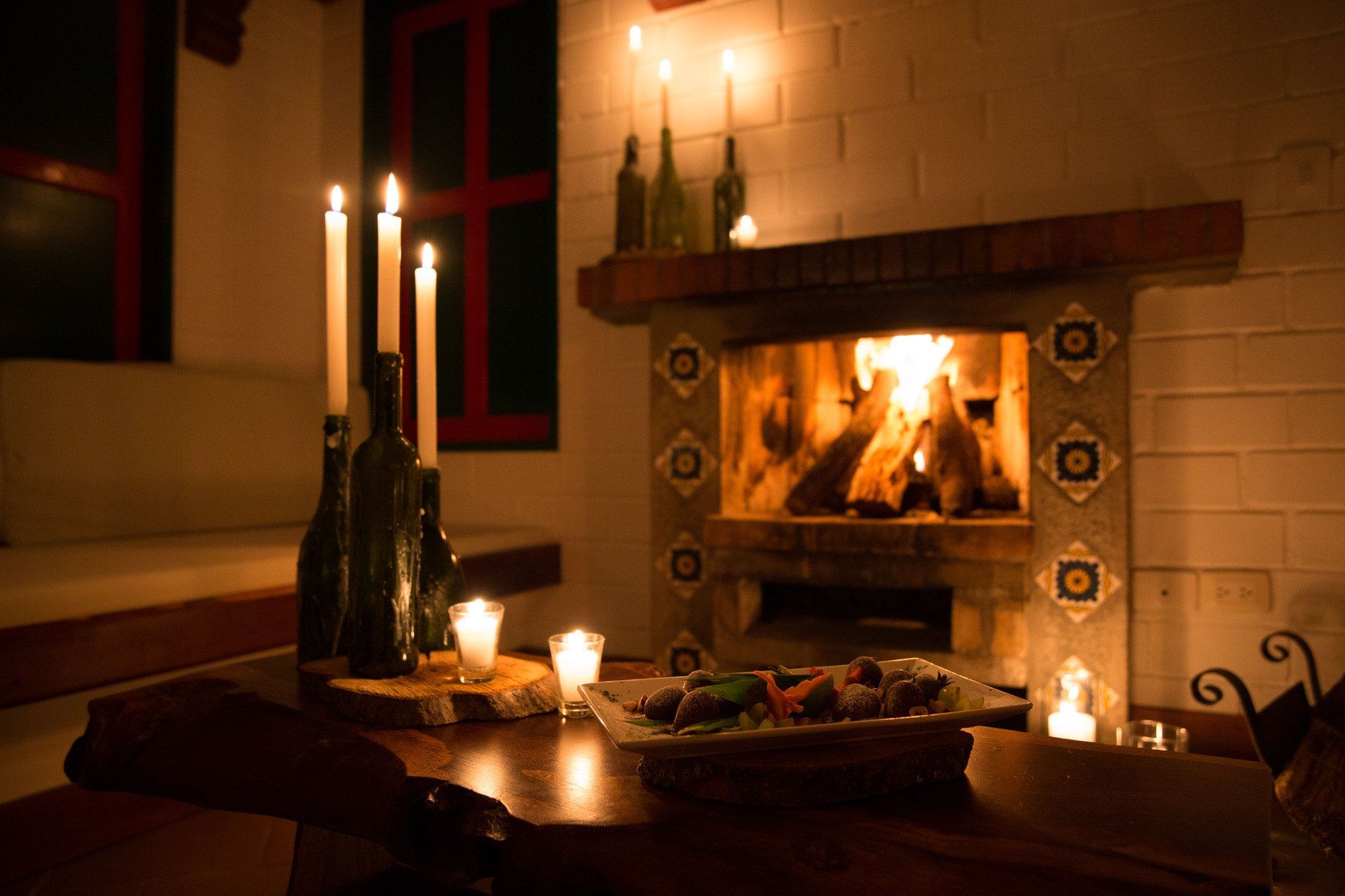 Lit fireplace with candles and an intimate atmosphere at Hotel Termales El Otoño, a romantic plan near Manizales.