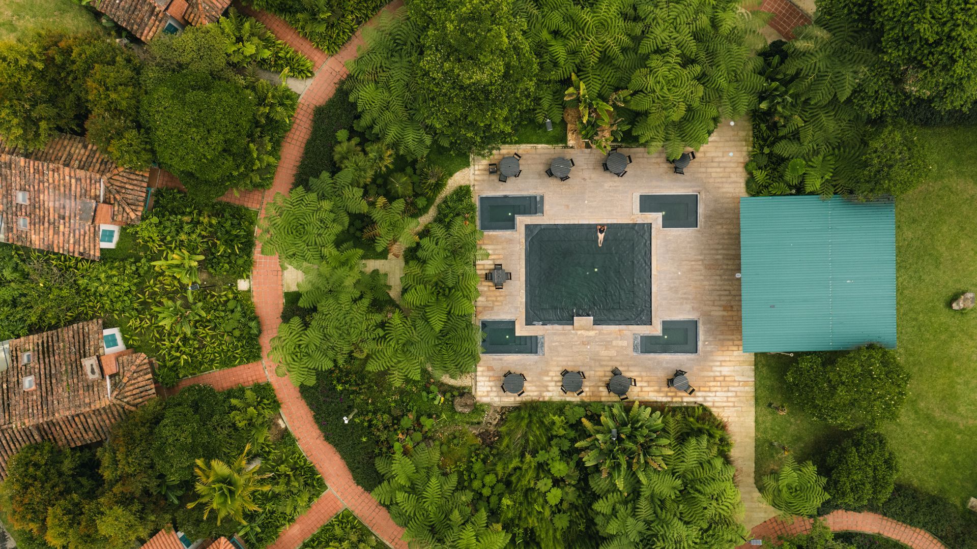 Vista aérea de La Herradura en Termales El Otoño, con piscina cuadrada, senderos y vegetación rodeando la zona de descanso.