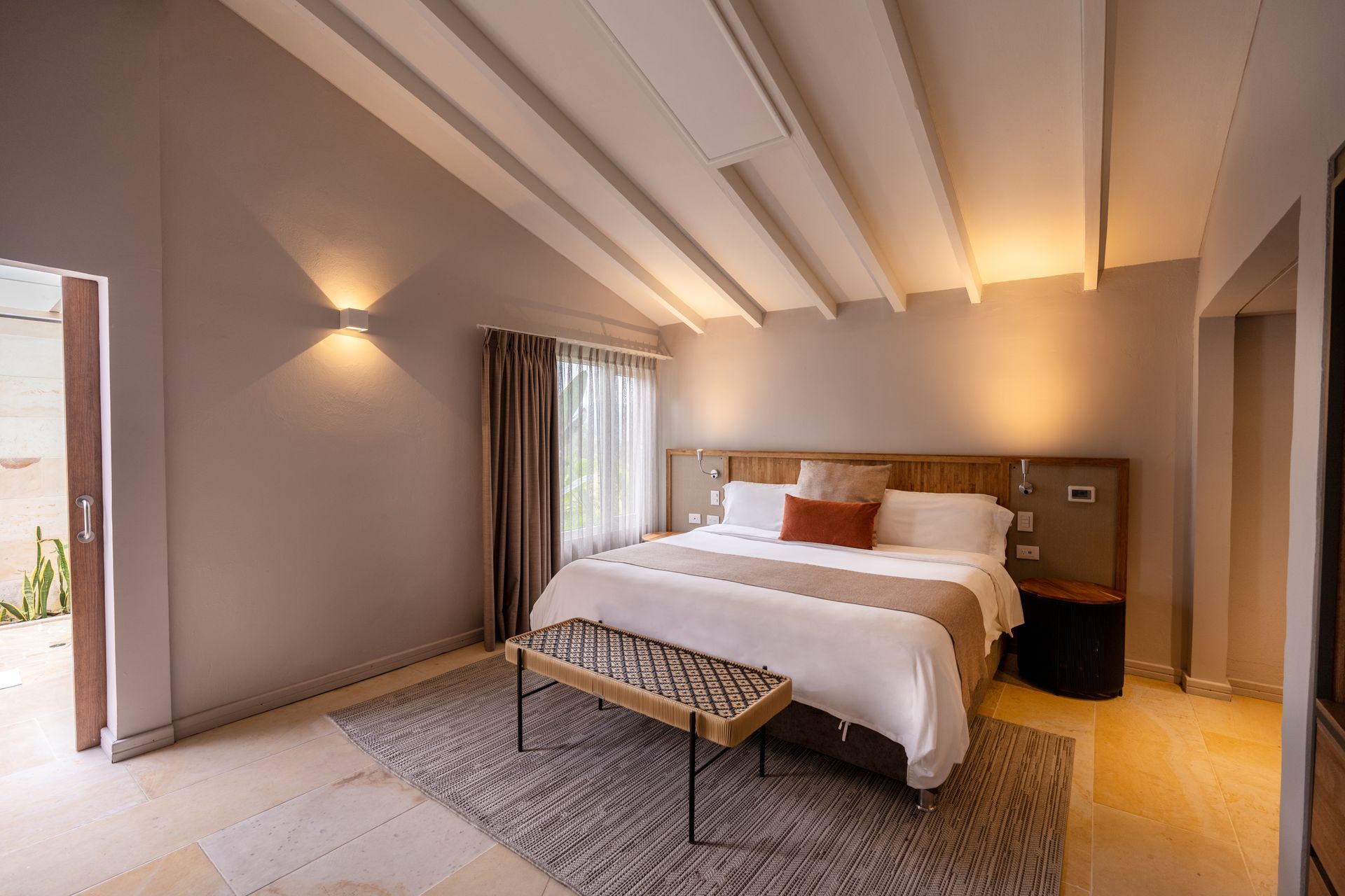 Habitación con cama doble, luz cálida y diseño sobrio en Termales El Otoño, hotel en Manizales para descanso y bienestar.