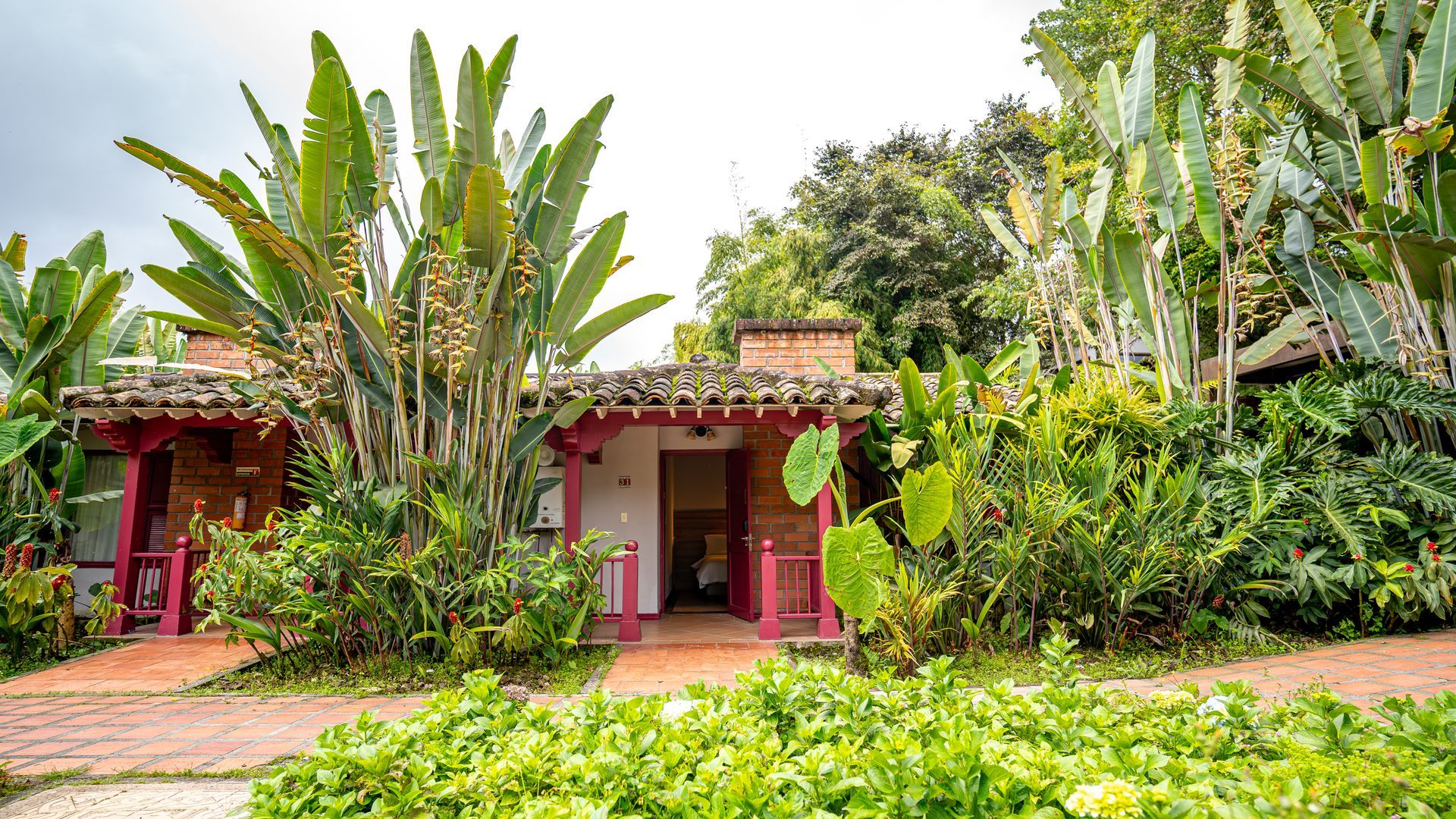 House surrounded by tropical gardens and vegetation at Termales El Otoño, one of the places to stay in the Coffee Region.