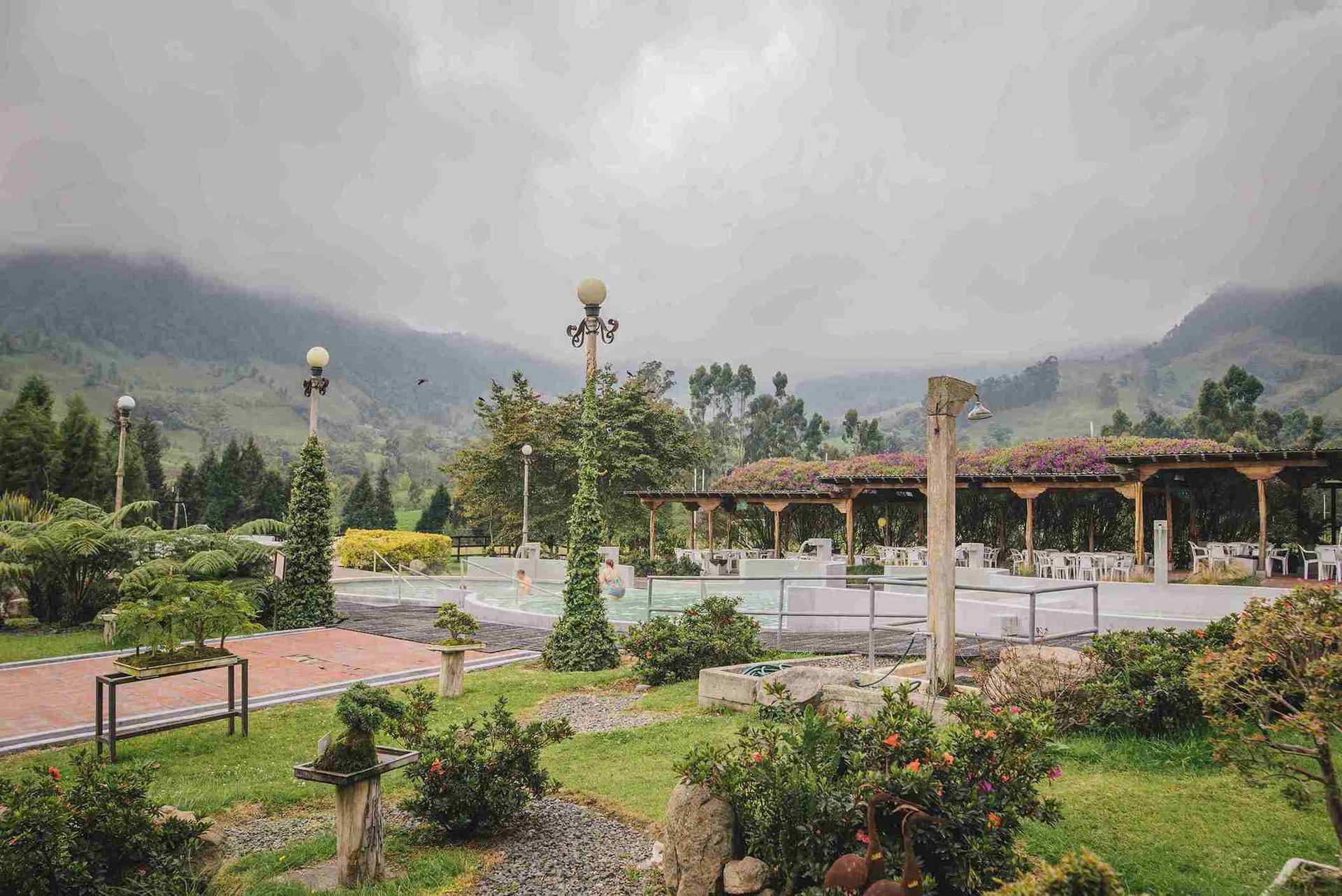 Hotel with a restaurant and bar for events in Manizales, featuring a central bar, tables, chairs, and wooden flooring.