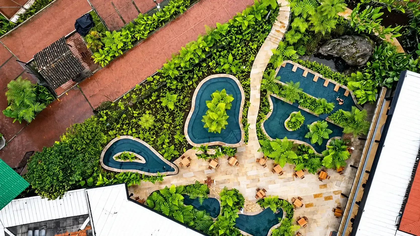 Vista aérea de charcos y piscinas de aguas termales rodeadas de jardines en Termales El Otoño, Manizales.