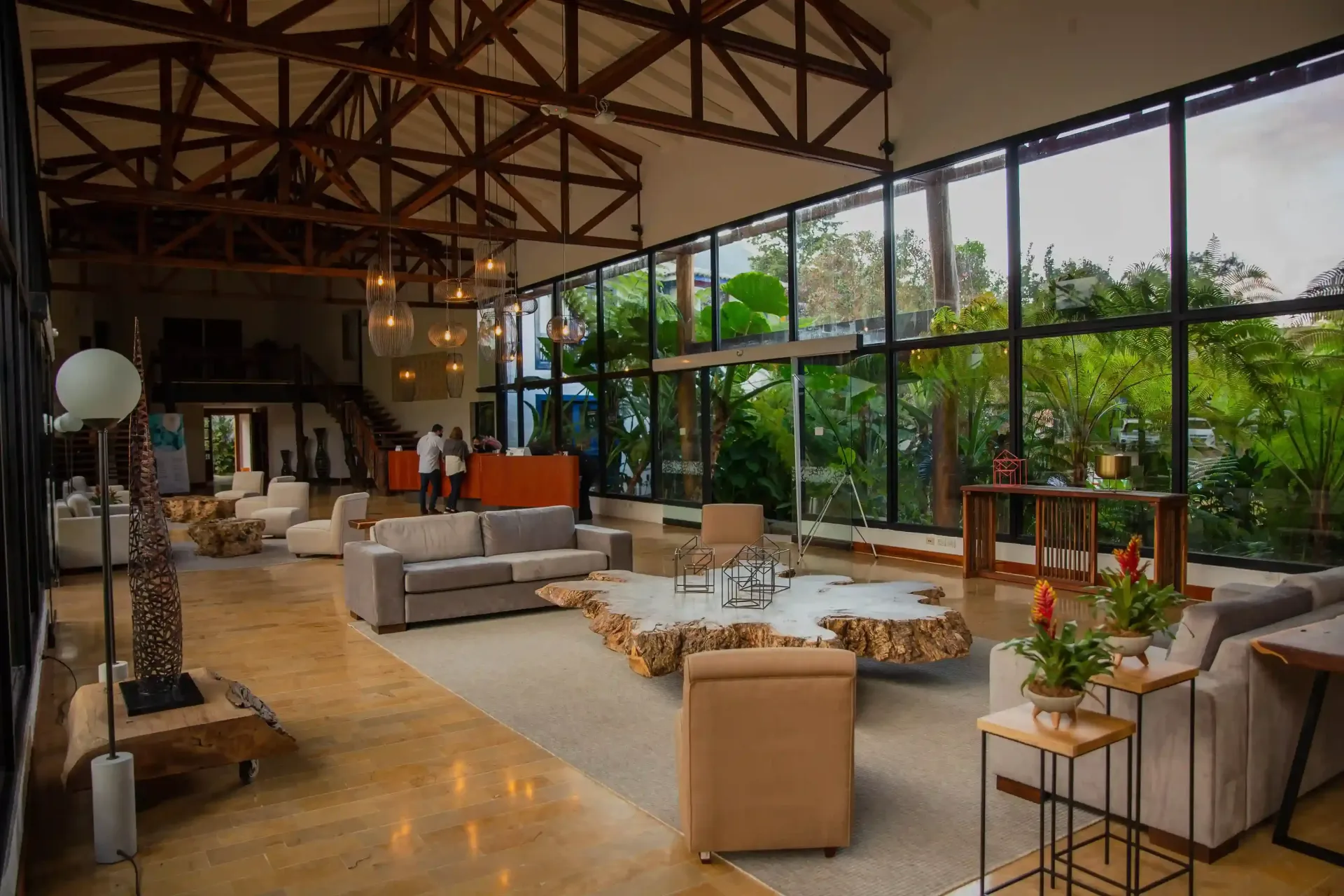 Lobby de Hotel Termales El Otoño, con decoración en madera, ventanales amplias, sala de estar y vista a jardines.