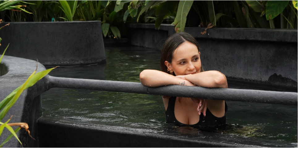 Woman relaxing by a thermal pool edge at Termales El Otoño, a wellness experience near Manizales hot springs.