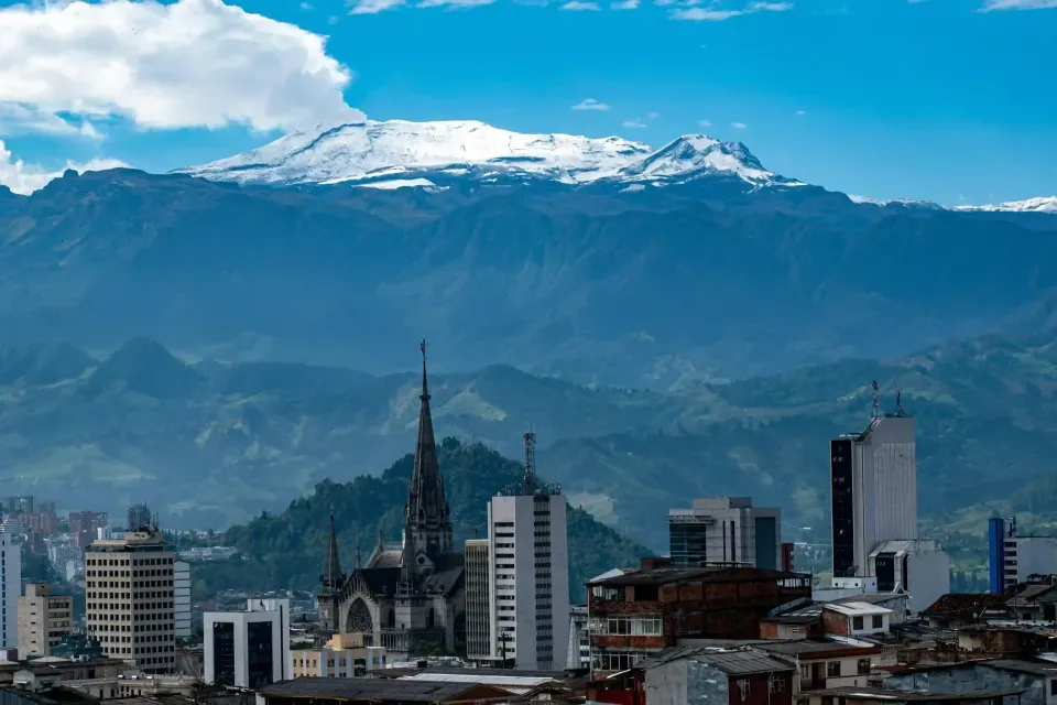 Vista de Manizales con catedral y montaña nevada al fondo, uno de los lugares para visitar en Colombia.