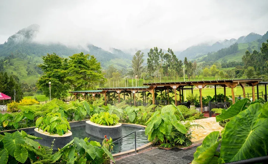 Piscina termal rodeada de jardines y montañas en Termales El Otoño, una experiencia de aguas termales en Manizales.