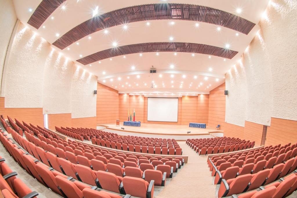 Salón para eventos o reuniones reuniones en Manizales, con sillas rojas, tarima amplia y pantalla en Termales El Otoño.