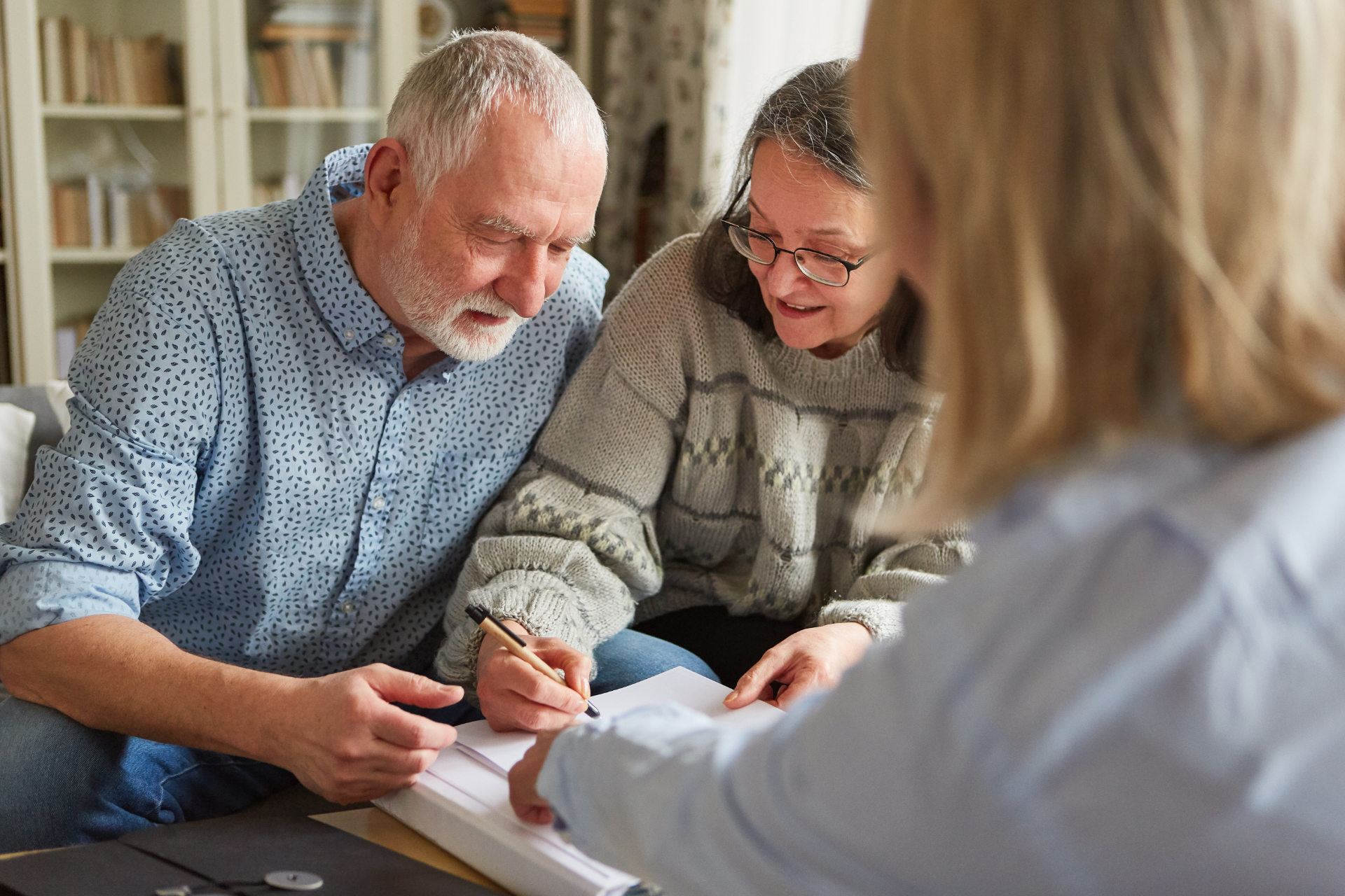Two people reviewing documents with a professional in a bright office setting