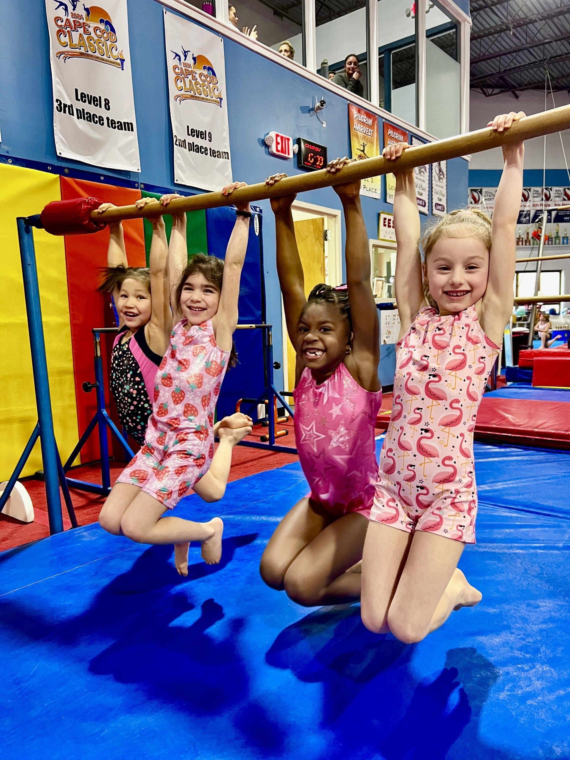 A little girl is doing a split on a blue mat