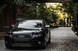 A black audi is parked in a driveway under a bridge | Collins Automotive