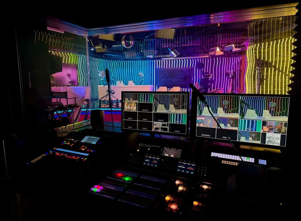 A recording studio with a lot of monitors and a microphone.