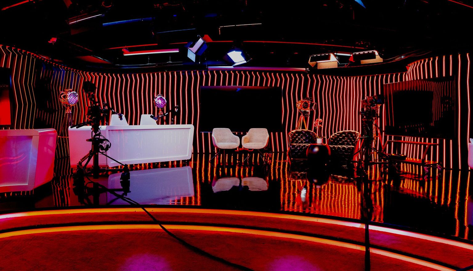 A television studio with a striped wall and a purple light.