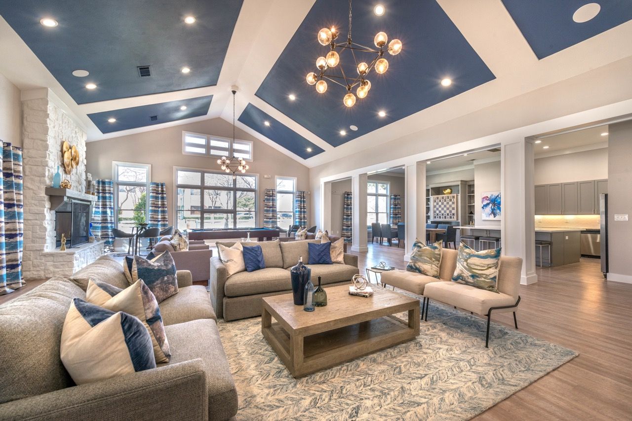 Spacious modern community lounge with seating, a fireplace, and large windows.