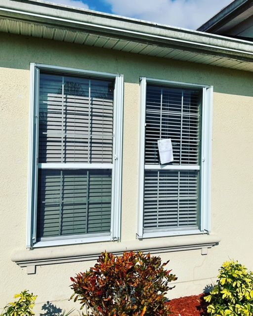 A house with two windows with blinds on them