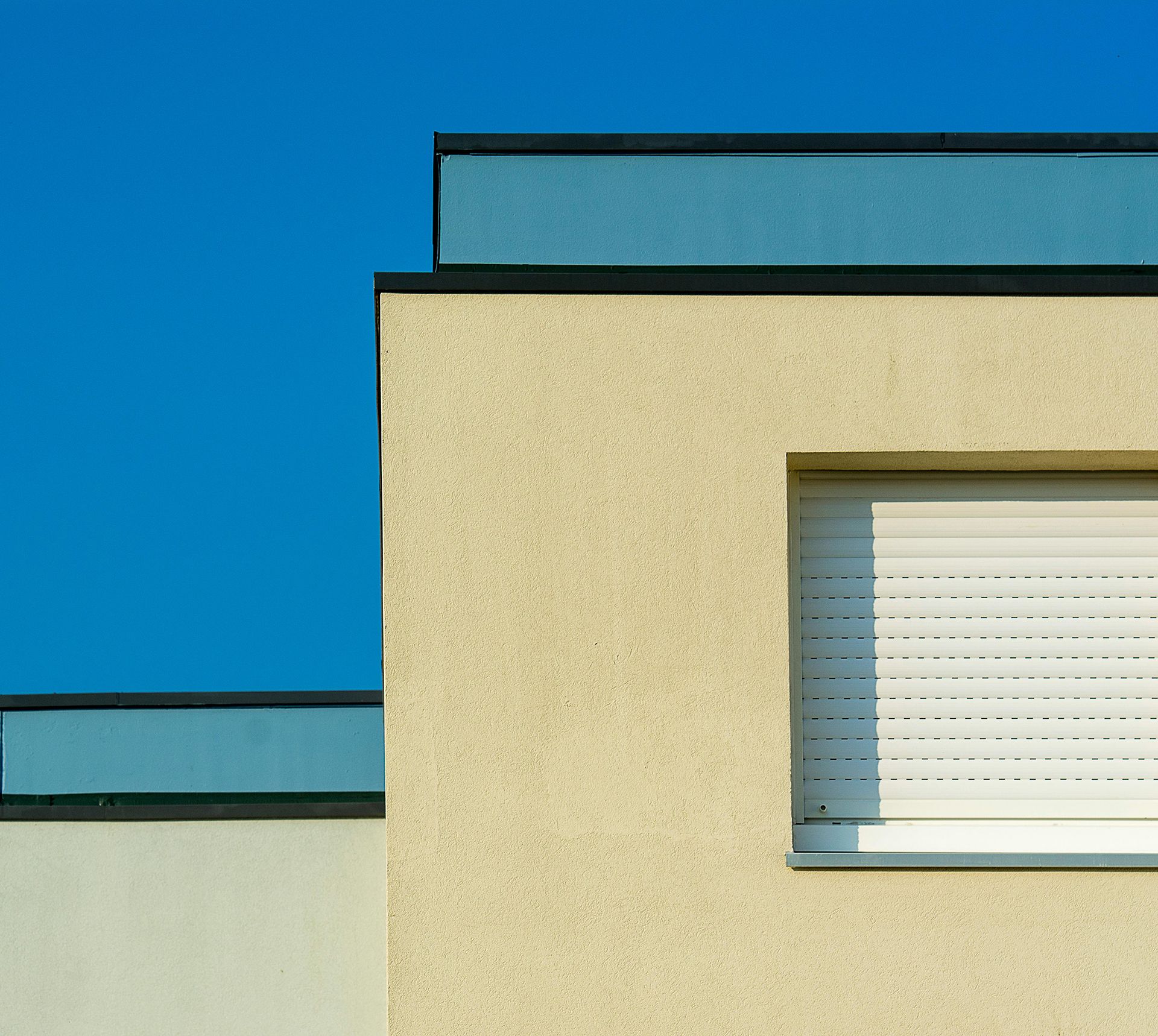 A building with a window and a blue sky in the background