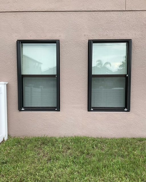 There are two windows on the side of a building
