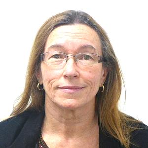 A woman wearing glasses and earrings is smiling for the camera.