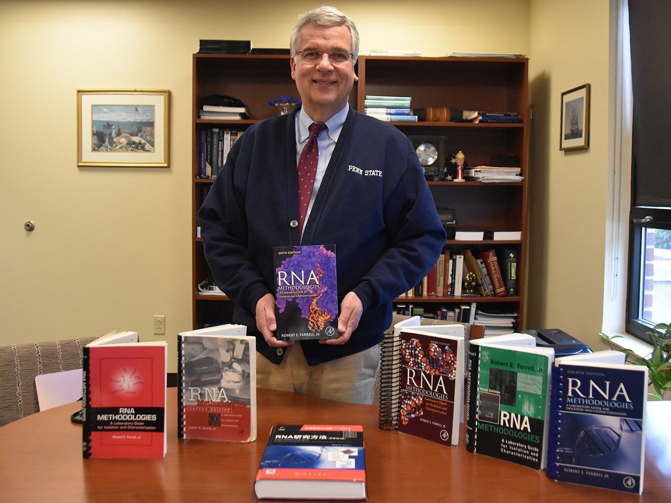 A man holding a book that says rna on it