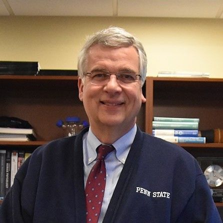 A man wearing a penn state sweater and tie