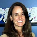 A woman with long brown hair is smiling for the camera.
