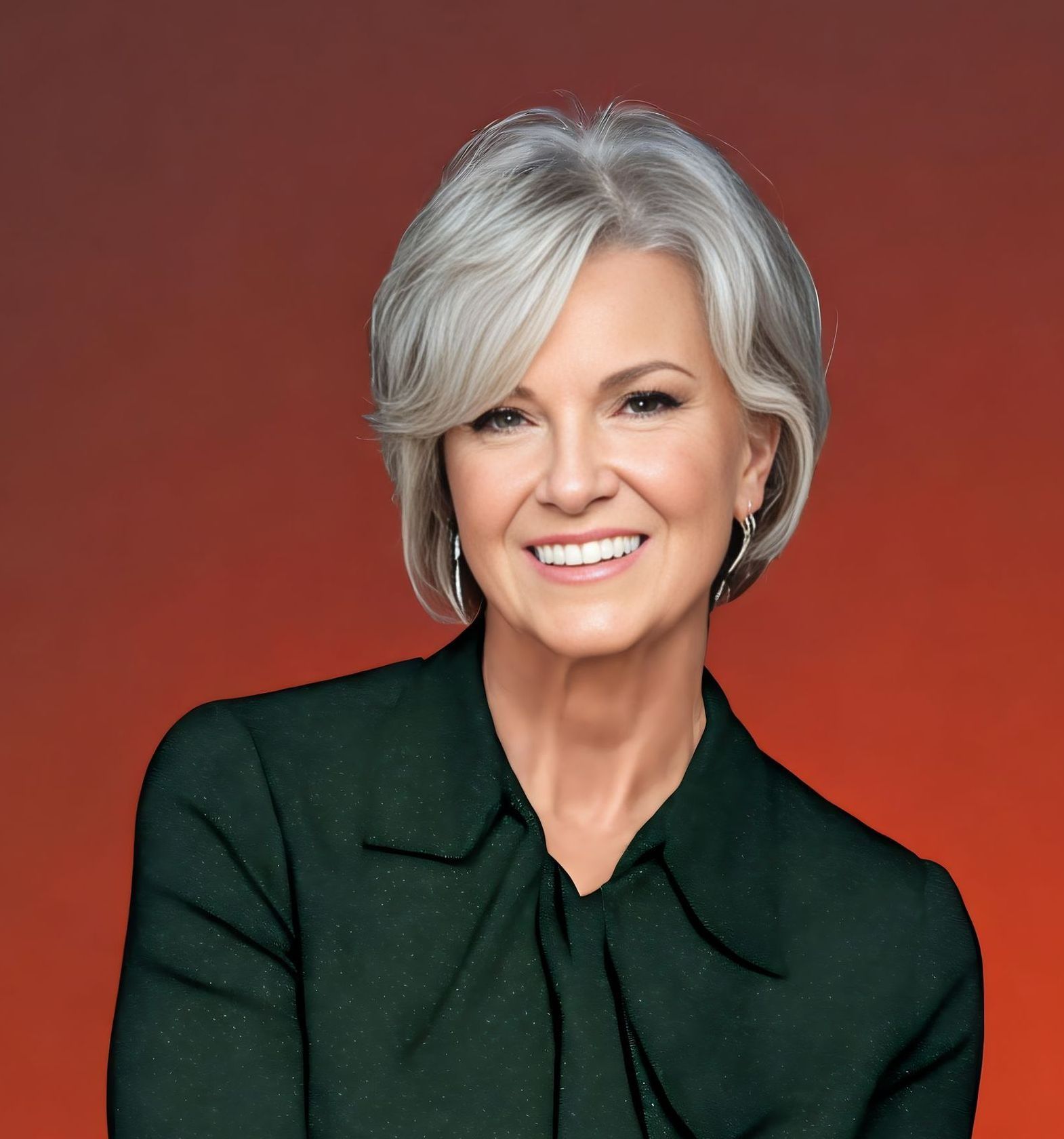 A woman with gray hair is smiling and wearing a green shirt