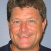 A man in a blue shirt is smiling for the camera.