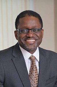 A man in a suit and tie is smiling for the camera.