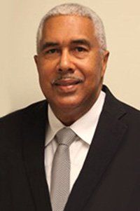 A man in a suit and tie is smiling for the camera.