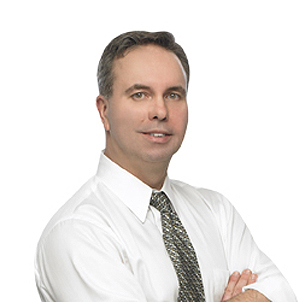 A man in a white shirt and tie with his arms crossed