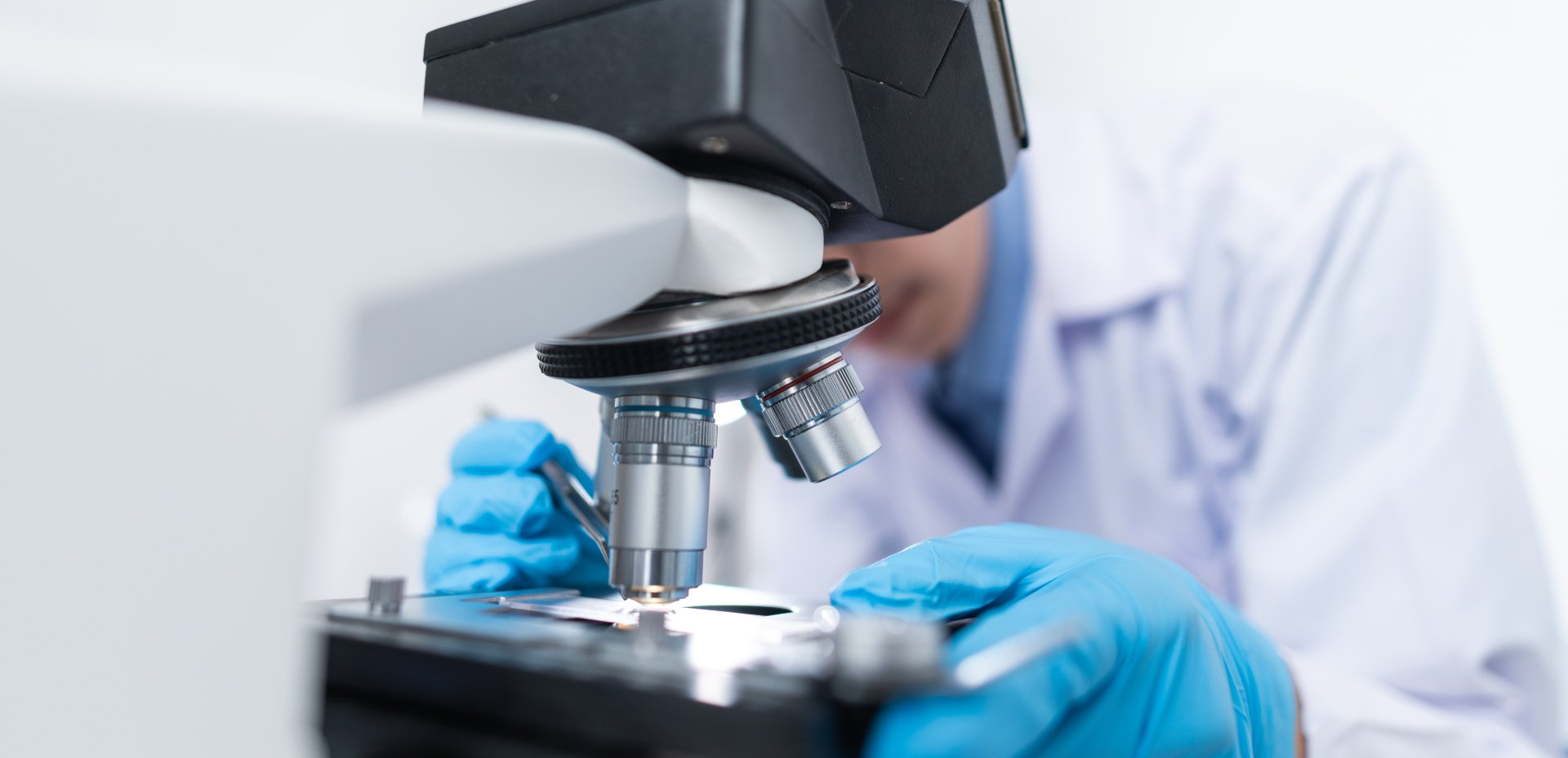 A scientist is looking through a microscope in a laboratory.