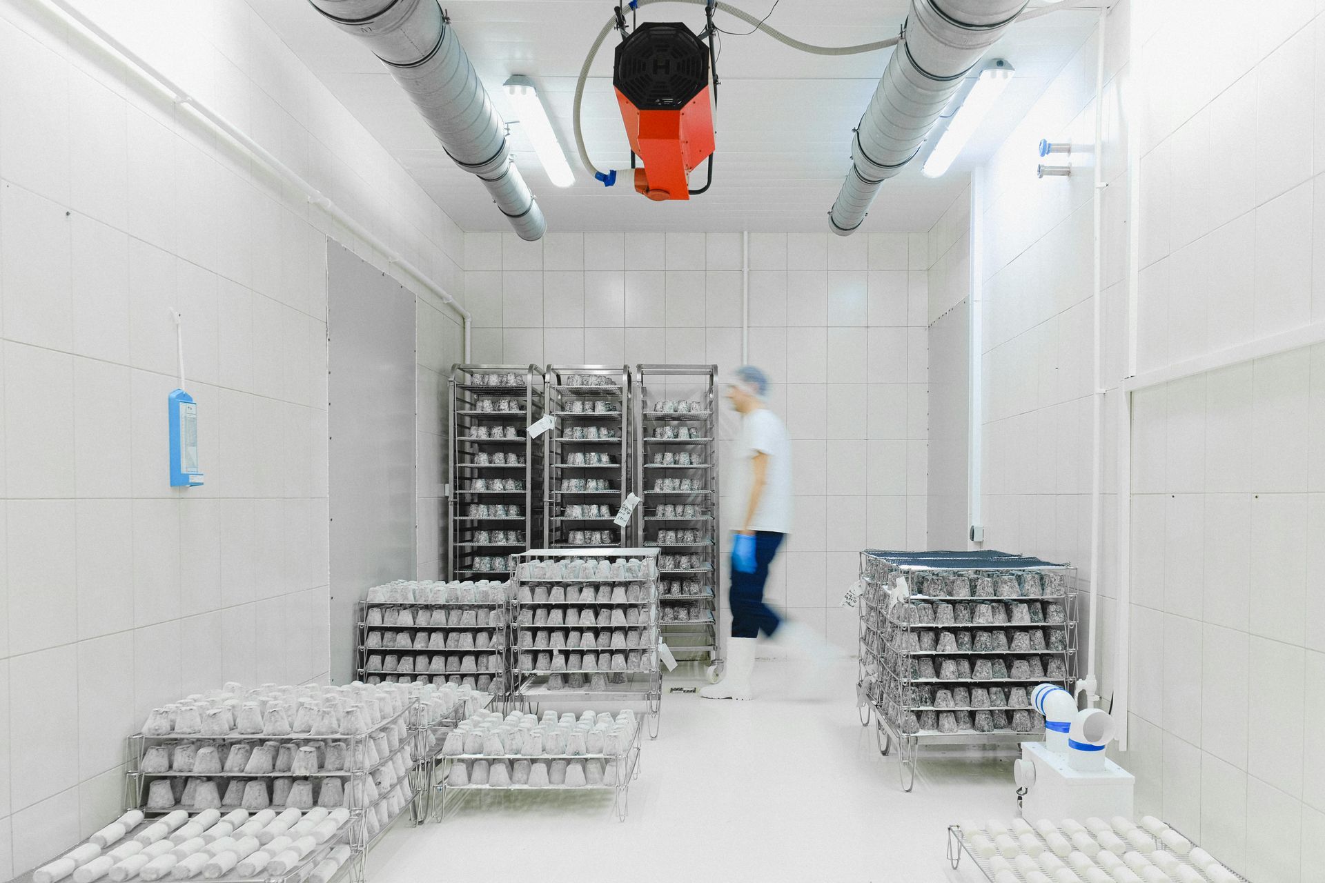 A person is standing in a stockroom filled with supplies. 