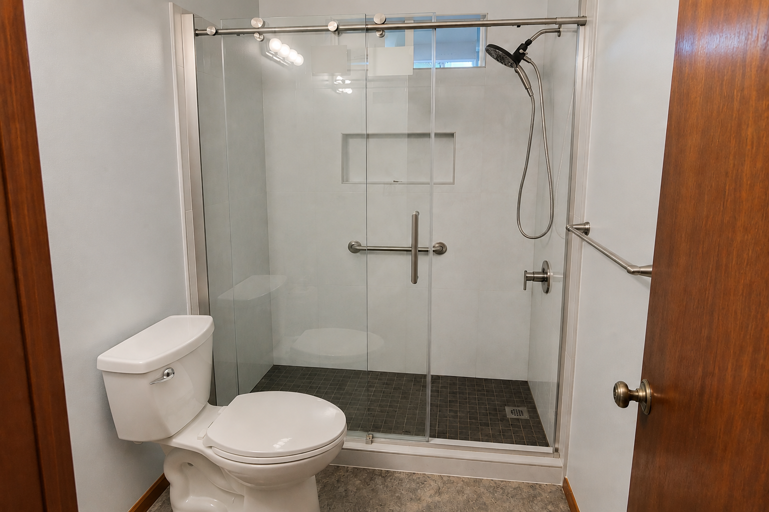 Bathroom with toilet and glass-enclosed shower in a tiled stall