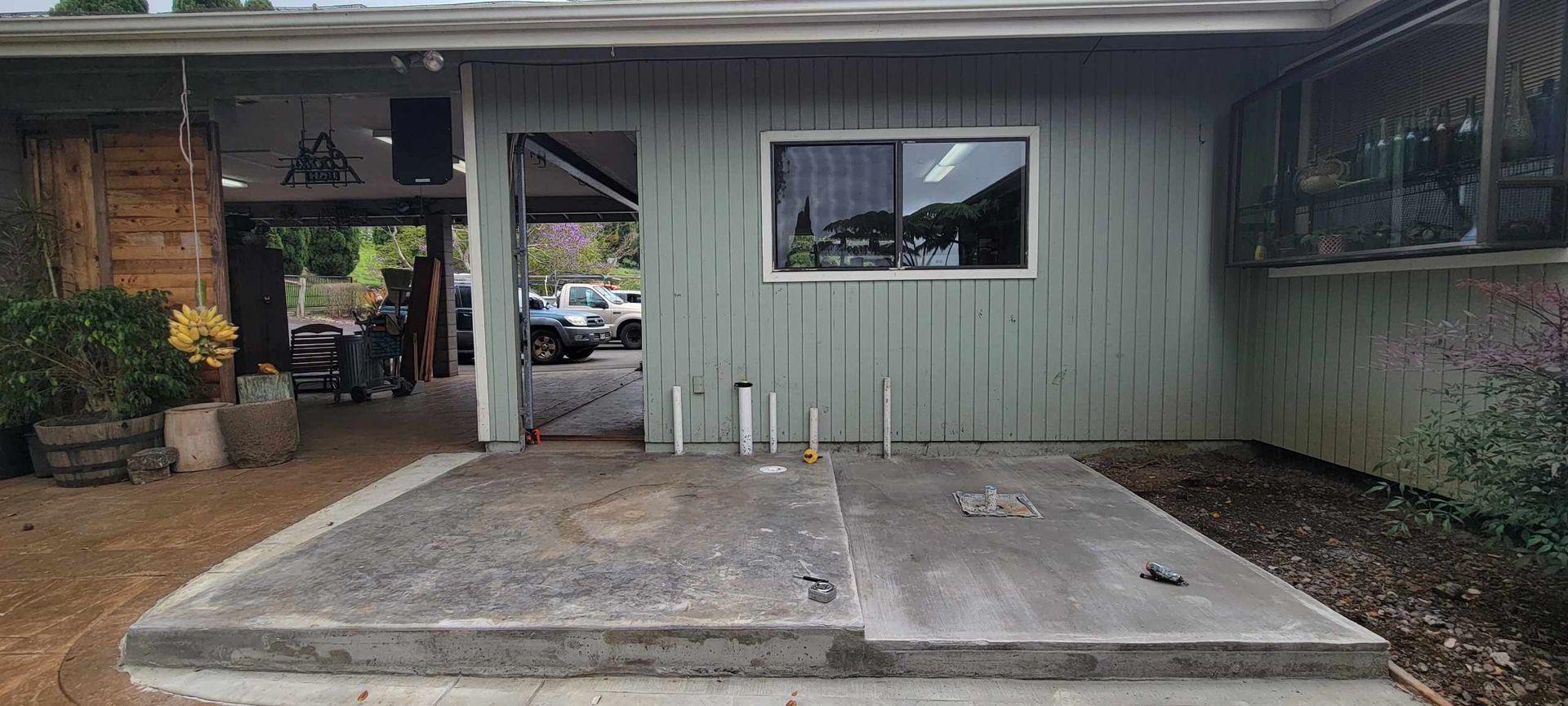 Concrete wheelchair ramp leading to a house entry with a window and patio area