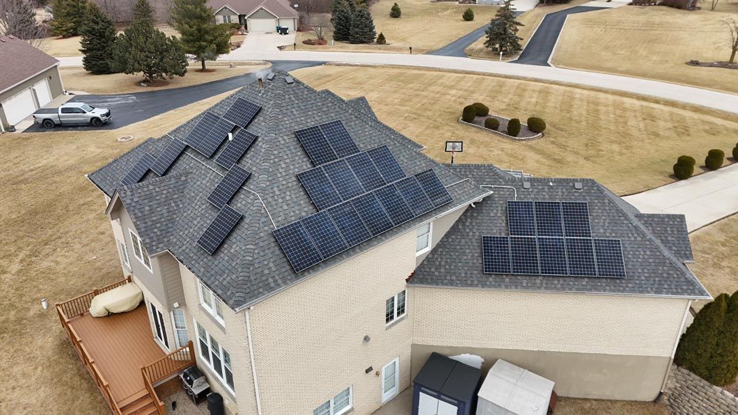 House with solar panels on the roof in a suburban neighborhood.
