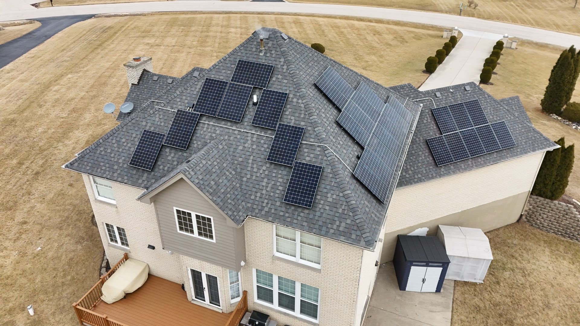 An aerial view shows a house with solar panels on the roof.