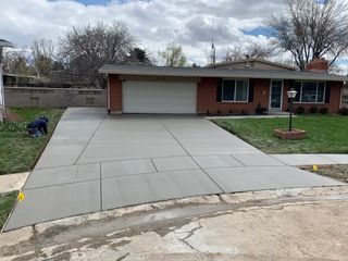 A concrete driveway is being built in front of a house.