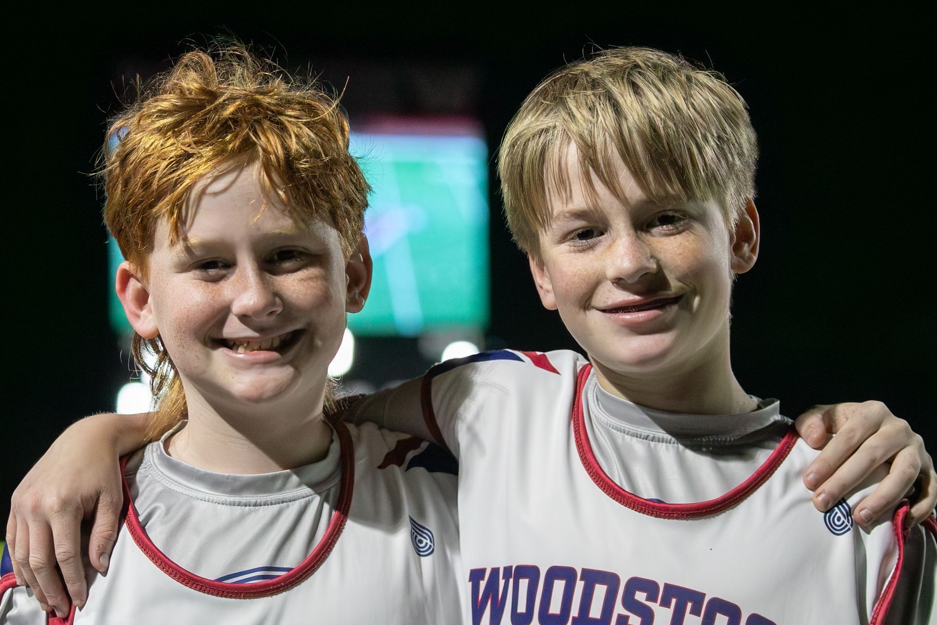 Two smiling athletes in white jerseys posing together at a sports event