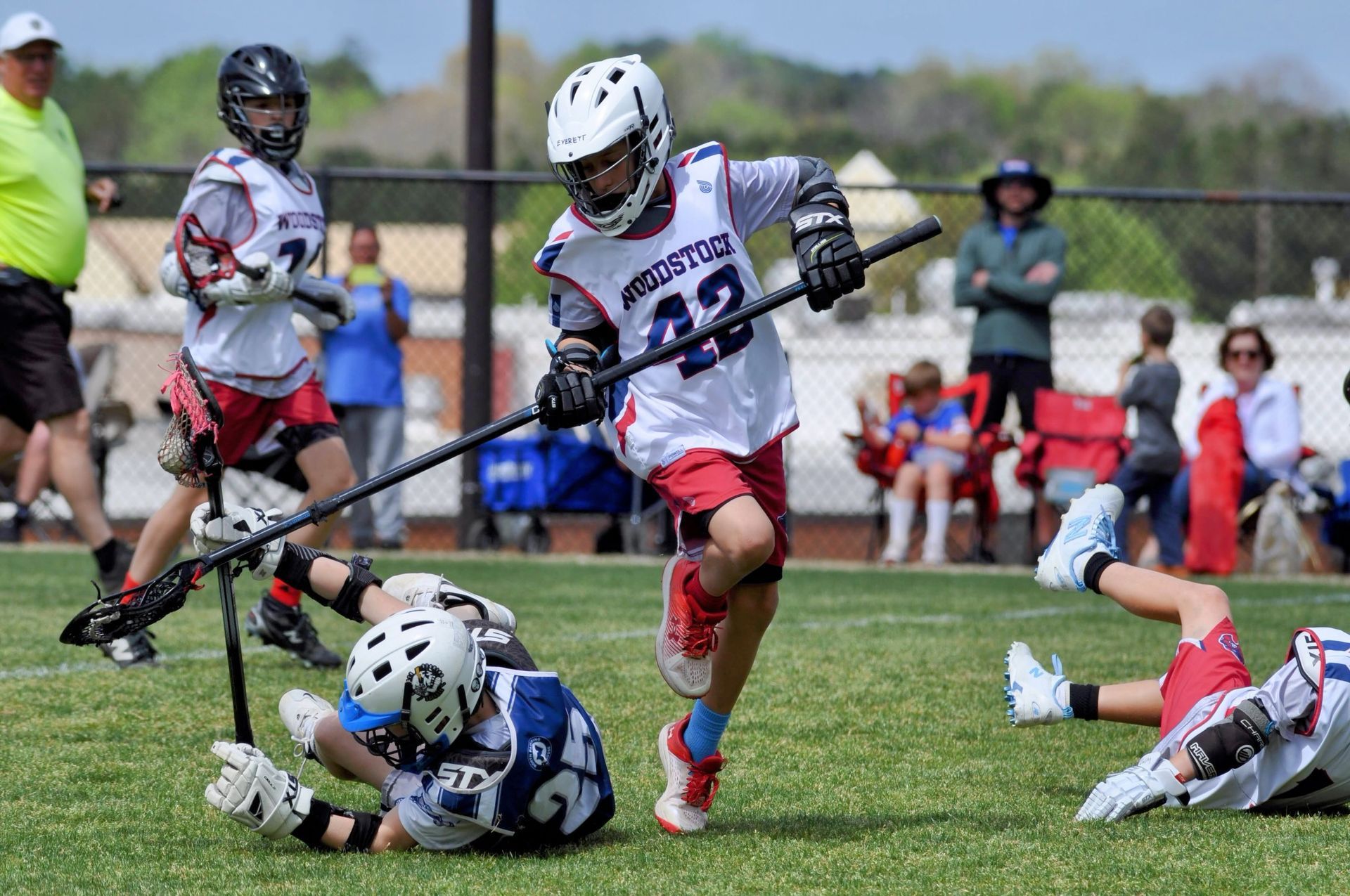 Youth lacrosse players battling for the ball on a sunny field